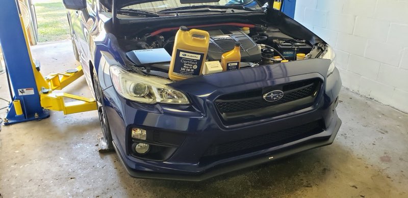 Blue Subaru WRX up on the lift for an oil service